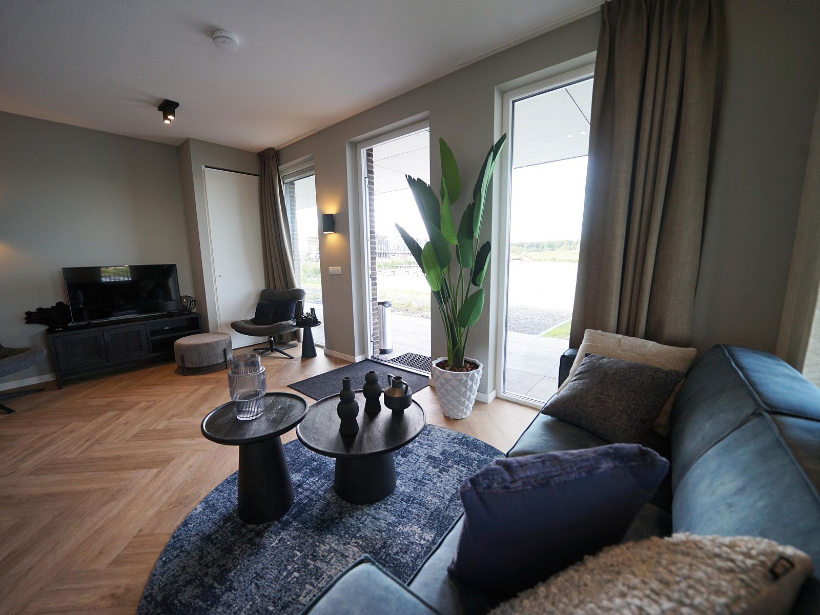 Stilvolles Wohnzimmer einer Wohnung in Kampen, Overijssel, mit gemtlicher Sitzecke und Blick auf die grne Umgebung.