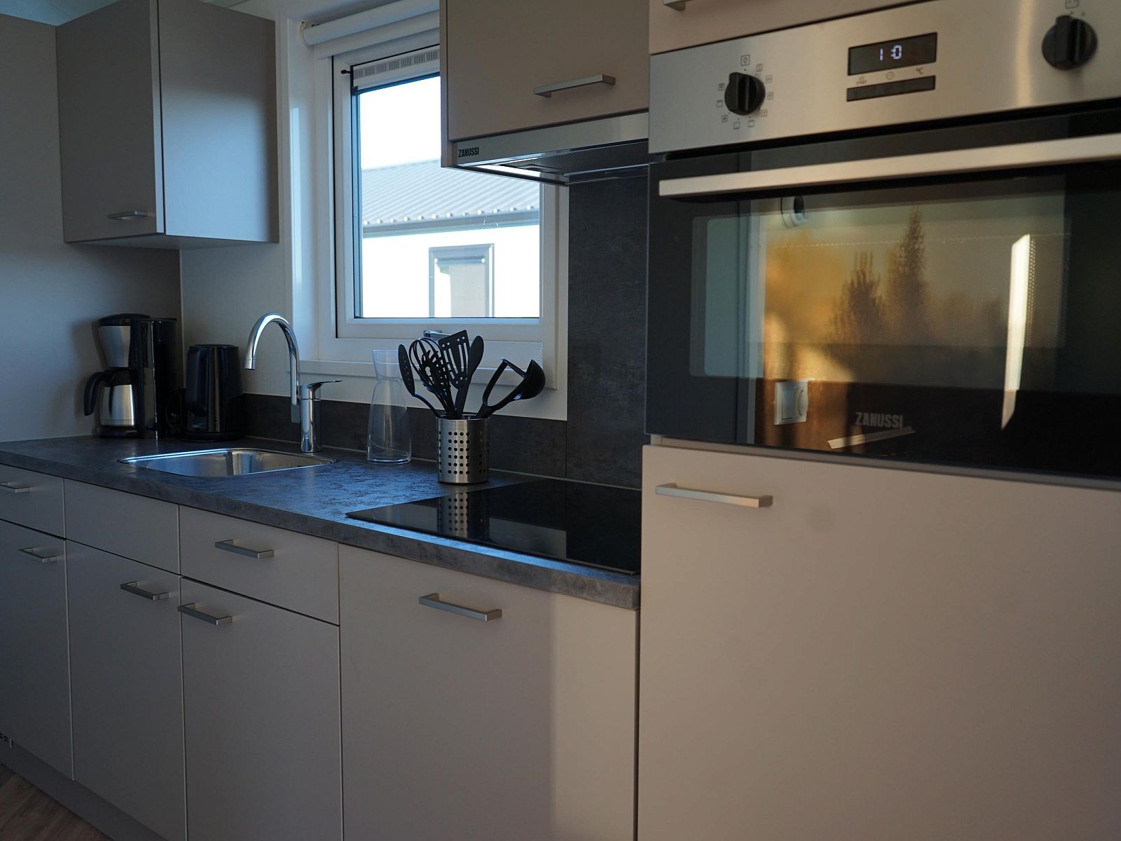 Moderne Kche in einem Einfamilienhaus in Kampen, Overijssel, mit schlichtem Design und Blick auf die Umgebung.