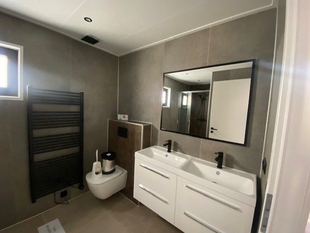 Modern bathroom in the detached house in Kampen, Overijssel, equipped with double sink and spacious mirror.