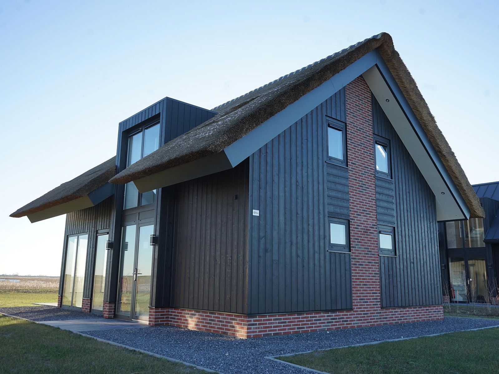 Vrijstaande woning in Kampen, Noordwest Overijssel, vakantiehuis met rieten dak en moderne architectuur, omgeven door natuur.