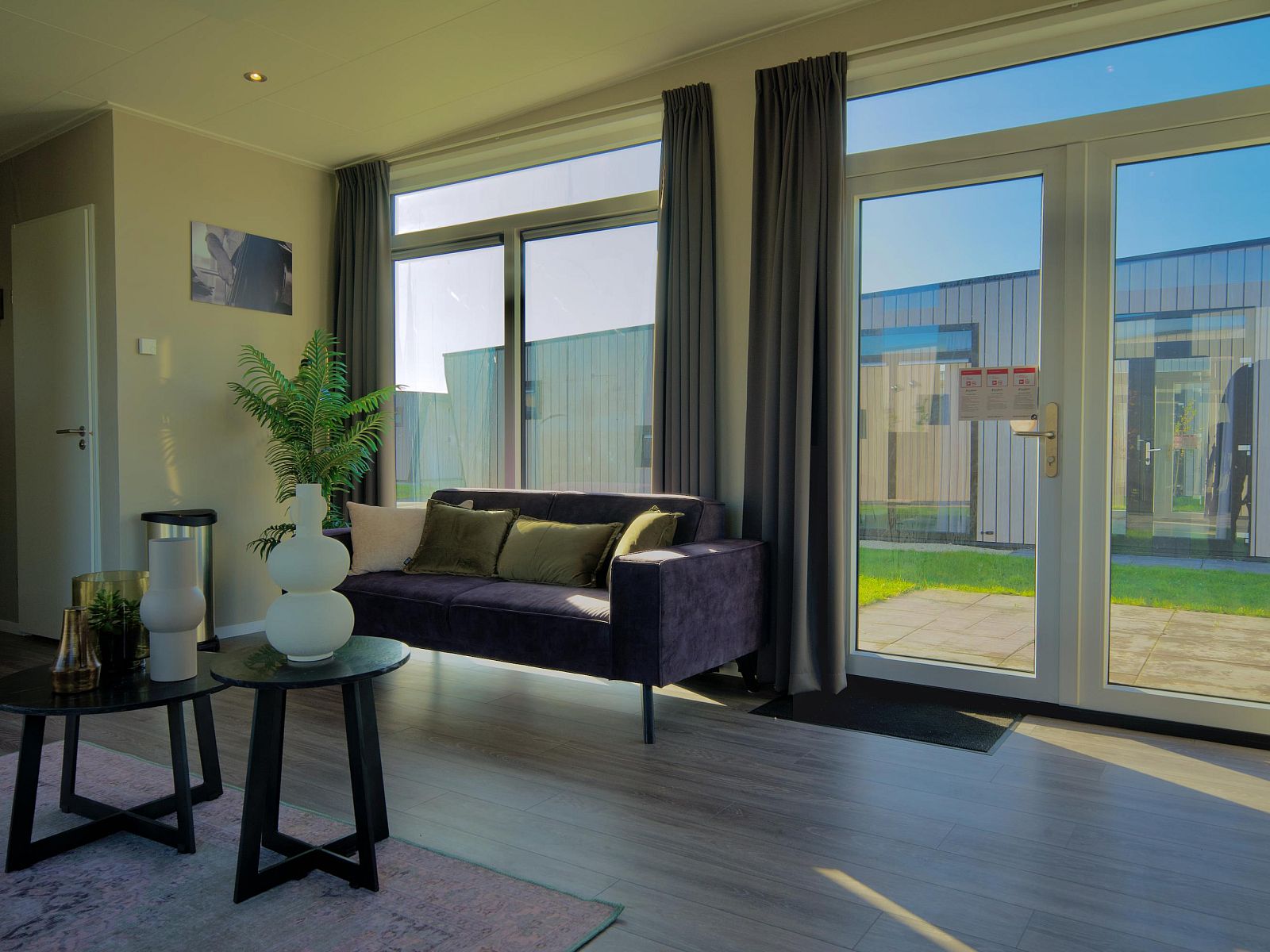 Lichte woonkamer van de Vrijstaande woning in Kampen, Overijssel met moderne inrichting en uitzicht op de tuin.