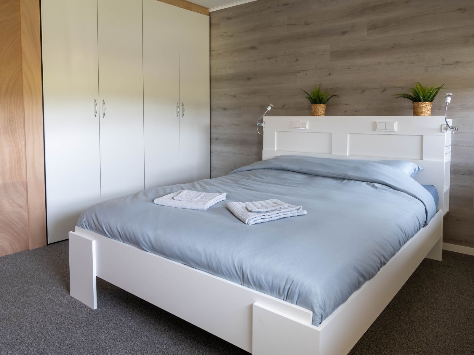 Gemuetliches Wohnzimmer im Ferienhaus OV700, Scheerwolde, mit bunten Kissen und Blumen in Overijssel.