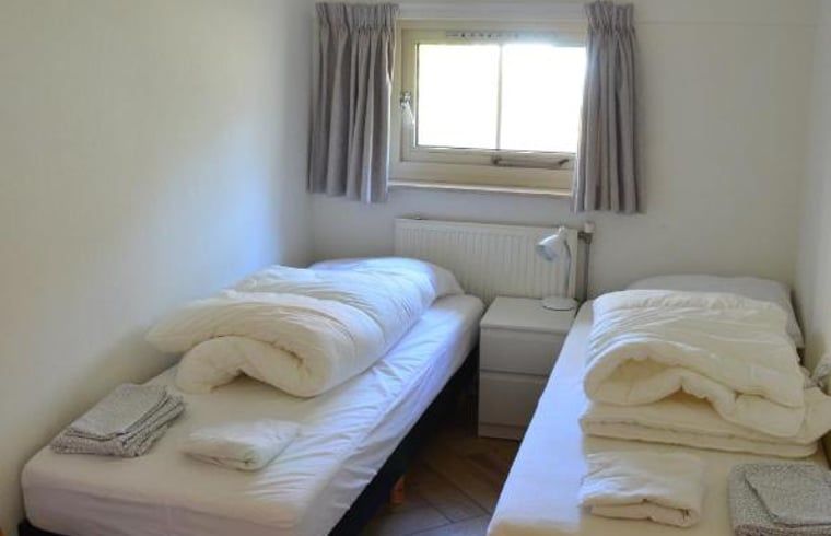 Komfortables Schlafzimmer mit zwei Betten in einem Ferienhaus in IJhorst, Overijssel.