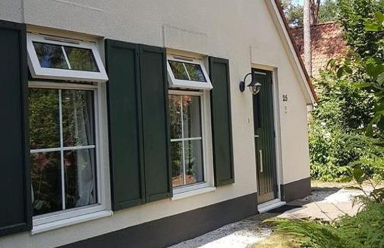 Vorderseite eines Ferienhauses in IJhorst mit traditionellen gruenen Fensterlaeden.