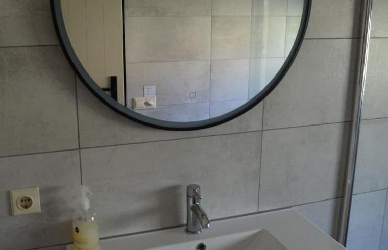 Modernes Waschbecken und Spiegel in einem Landhaus in IJhorst, Overijssel.