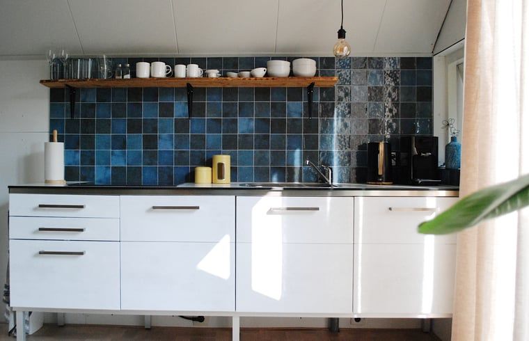 Modern kitchen in Holiday Home in IJhorst, Northwest Overijssel, with stylish tiles and practical furnishings for a comfortable stay.