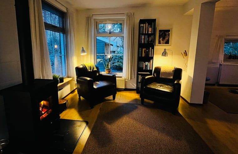 Stilvolle Chaiselongue im Ferienhaus in IJhorst, umgeben von Buechern und gruener Aussicht in Overijssel.