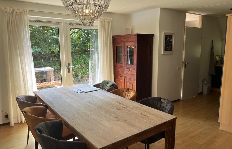 Geraeumiges Wohnzimmer mit Sitzecke und Kaminofen im Ferienhaus in IJhorst, ideal fuer einen entspannten Urlaub.