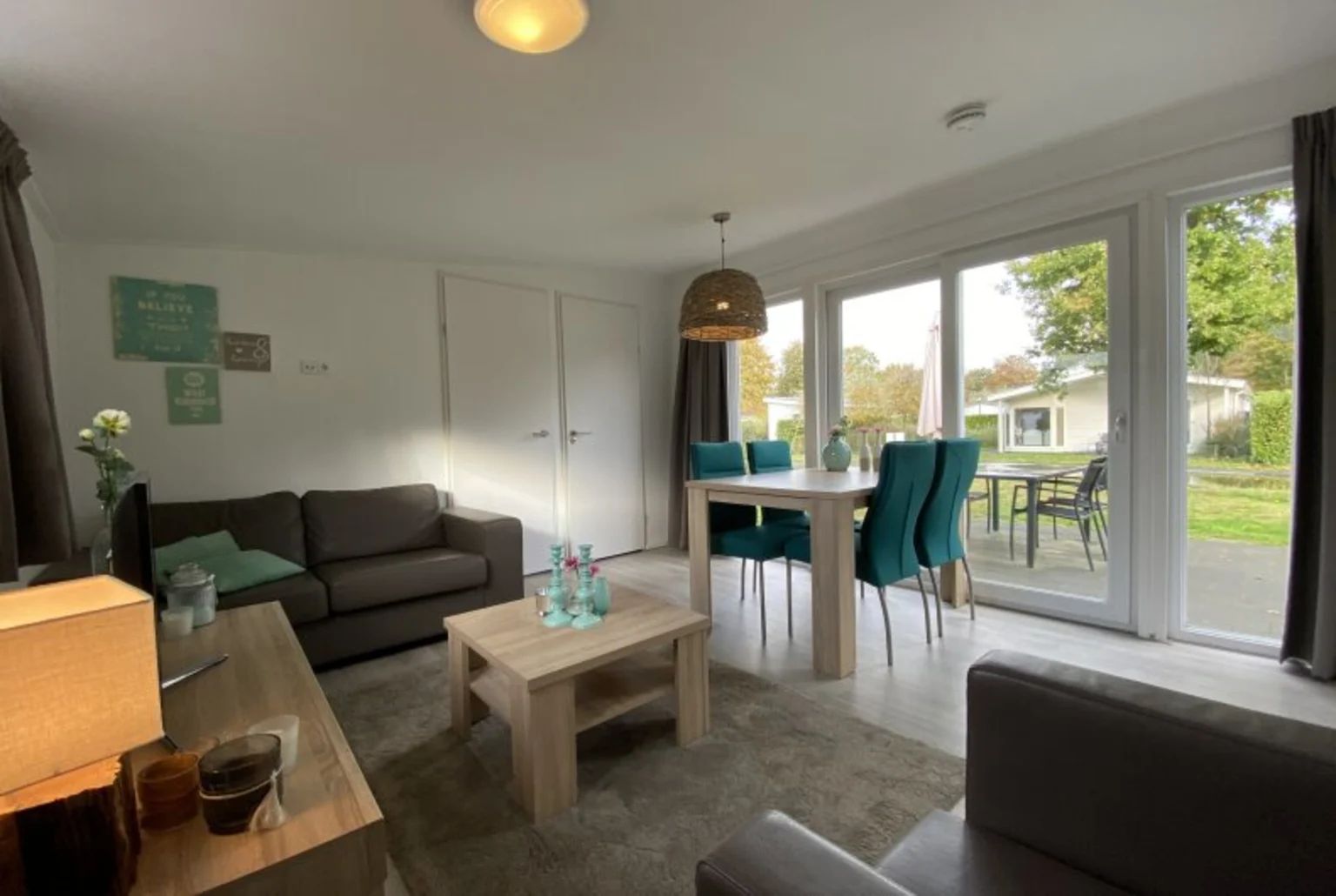 Gemtliches Wohnzimmer eines freistehenden Hauses in IJhorst, Nordwest-Overijssel. Genieen Sie den Blick auf den Garten von diesem komfortablen Ferienhaus aus.