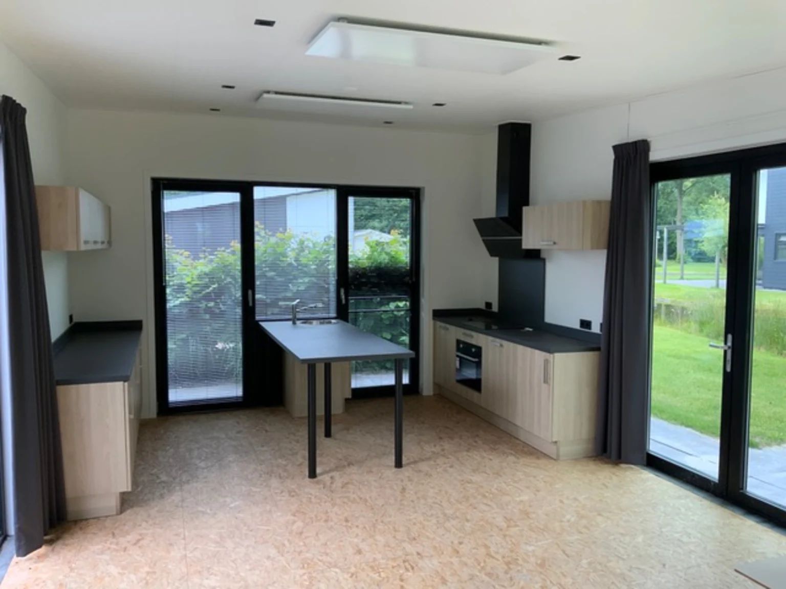 Moderne keuken in vrijstaande woning in IJhorst, Overijssel, met uitzicht op groene omgeving en veel natuurlijk licht.