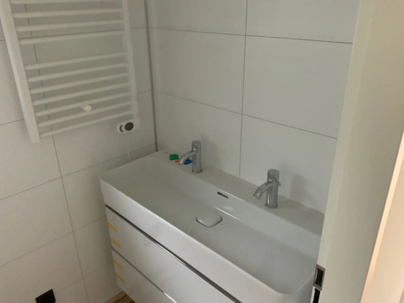 Moderne badkamer in Vrijstaande woning in IJhorst, Noordwest Overijssel, met dubbele wastafel en strakke witte tegels.