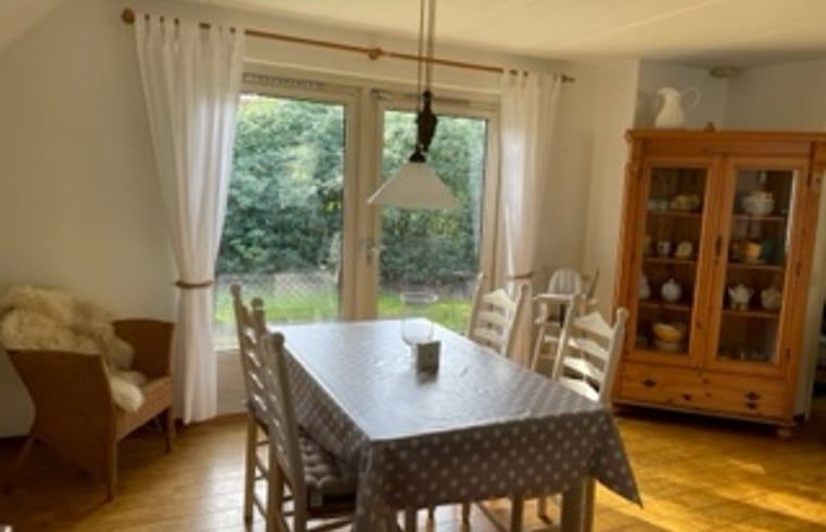Dining room of Holiday home in IJhorst overlooking green garden, ideal for cozy meals.