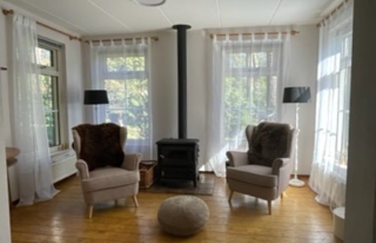 Bright living room of Holiday home in IJhorst with wood stove, perfect for cozy evenings.
