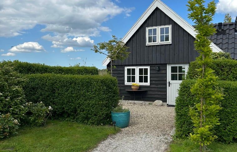 Charmant vakantiehuis in Kalenberg, Noordwest Overijssel, omringd door groene tuinen en blauwe luchten, ideaal voor een ontspannen verblijf.