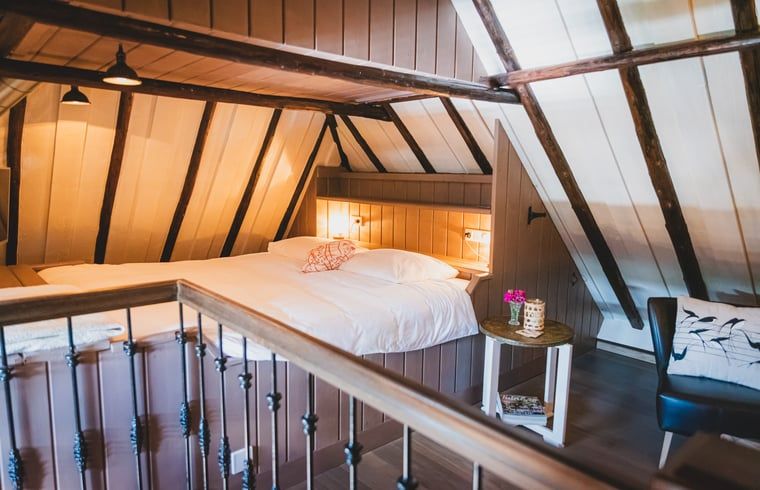 Gezellige slaapruimte in Vakantiehuis in Sint Jansklooster, Overijssel, met houten balkenplafond.