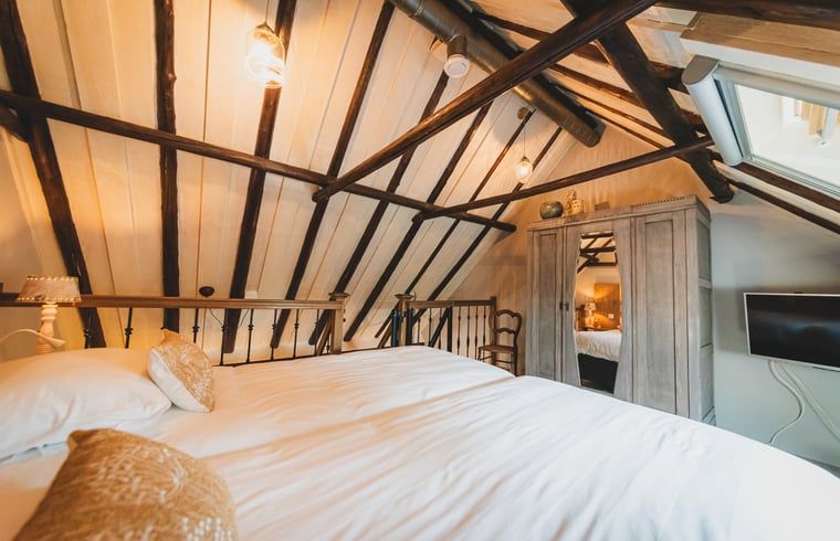 Gezellige slaapkamer met houten balken in Vakantiehuis in Sint Jansklooster, Overijssel.