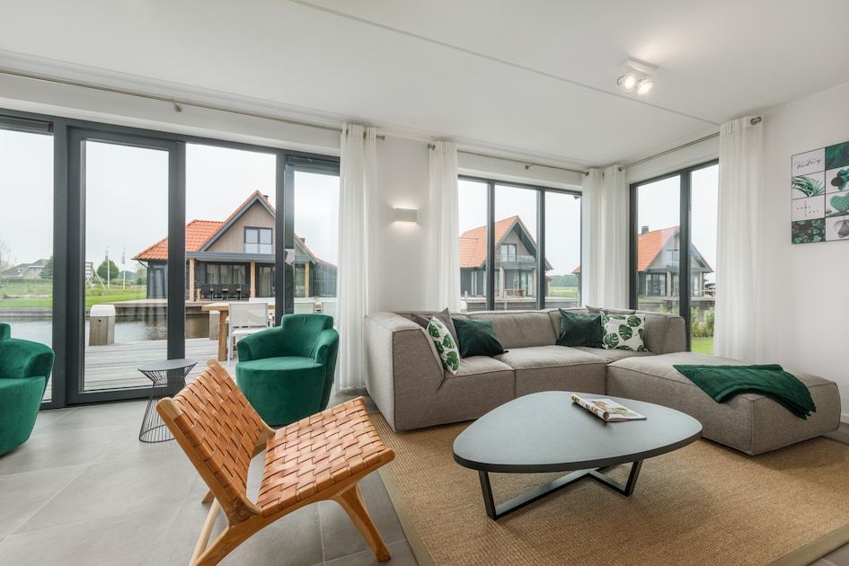 Lichte woonkamer in Watervilla 8, een vakantiehuis in Ossenzijl, Noordwest Overijssel, met uitzicht op het water en moderne inrichting.