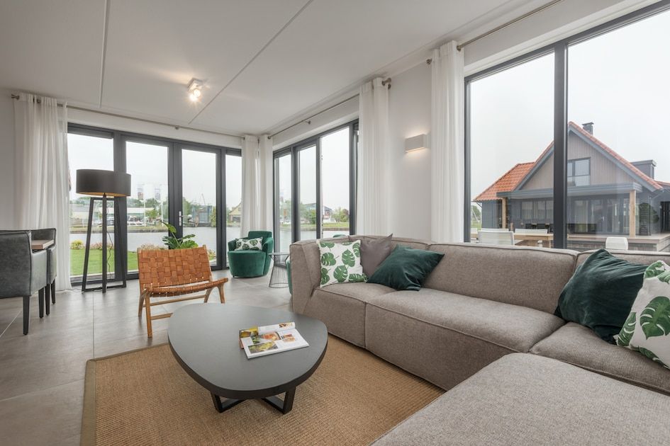 Moderne woonkamer in Watervilla 8, vakantiehuis in Ossenzijl, Noordwest Overijssel, met ruime zithoek en veel natuurlijk licht.