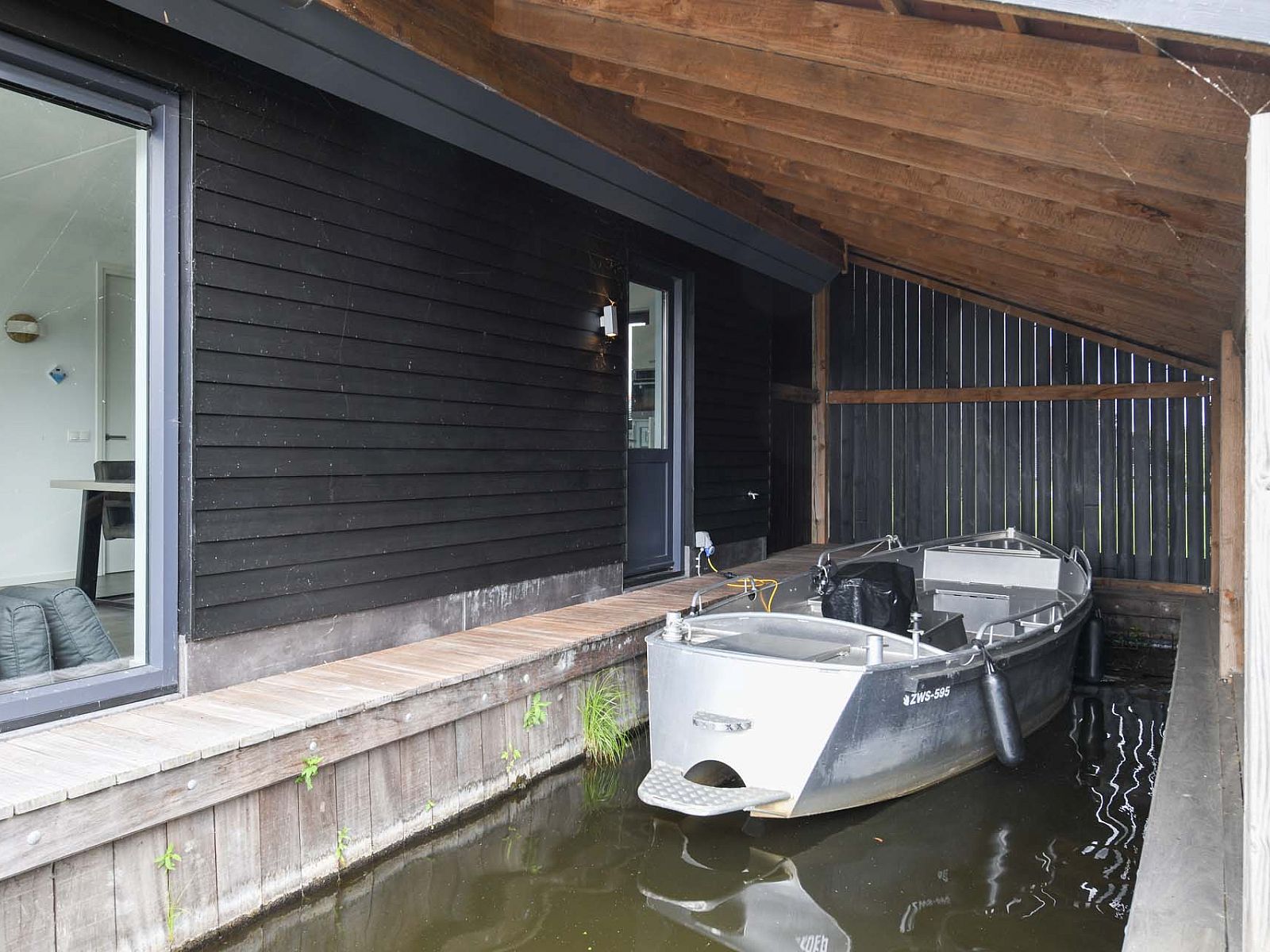 Boot mit berdachtem Liegeplatz in einem Einfamilienhaus in Ossenzijl, Nordwest-Overijssel, Overijssel.