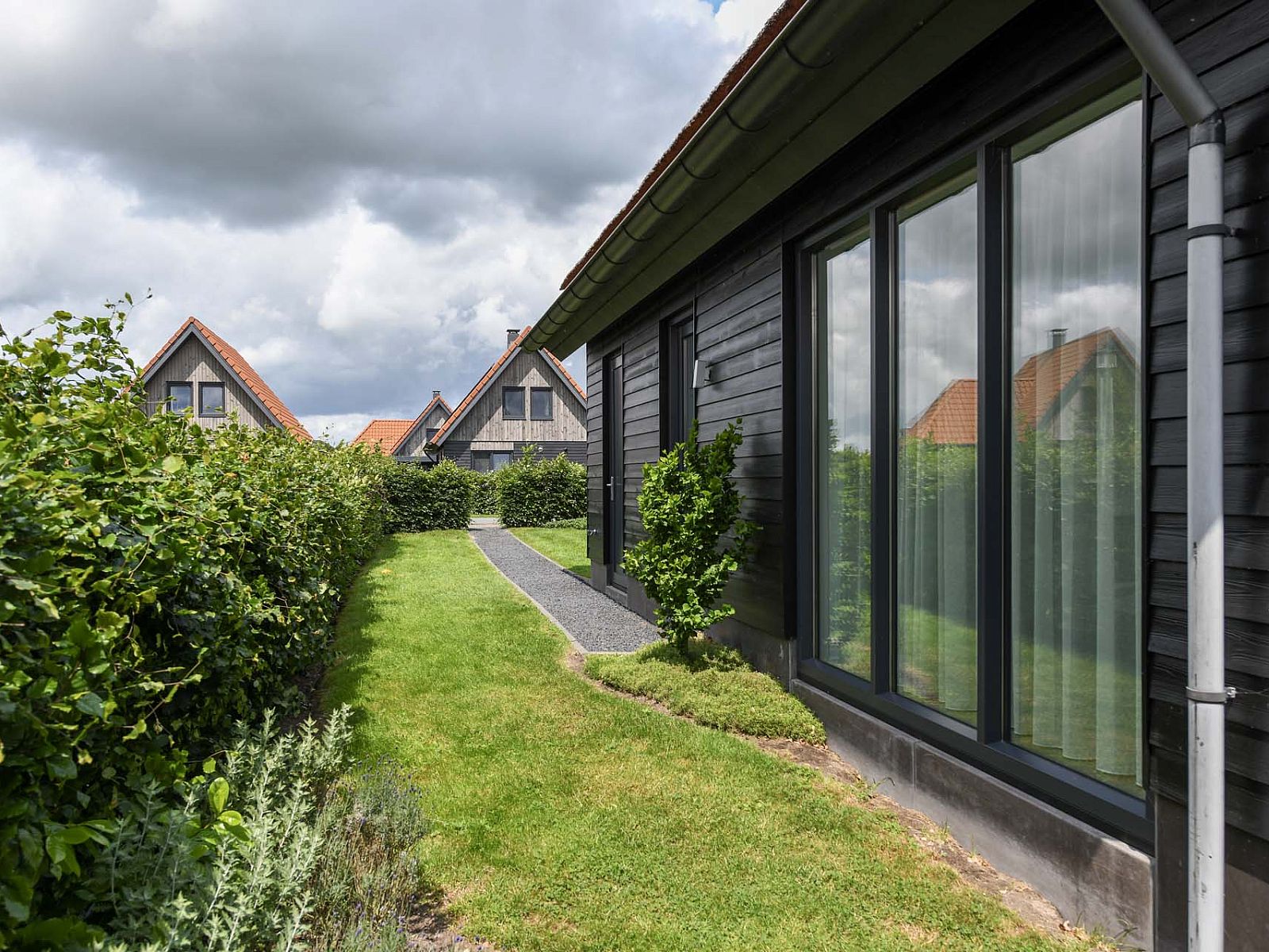 Weg entlang des Gartens eines Einfamilienhauses in Ossenzijl, Nordwest Overijssel, Overijssel.