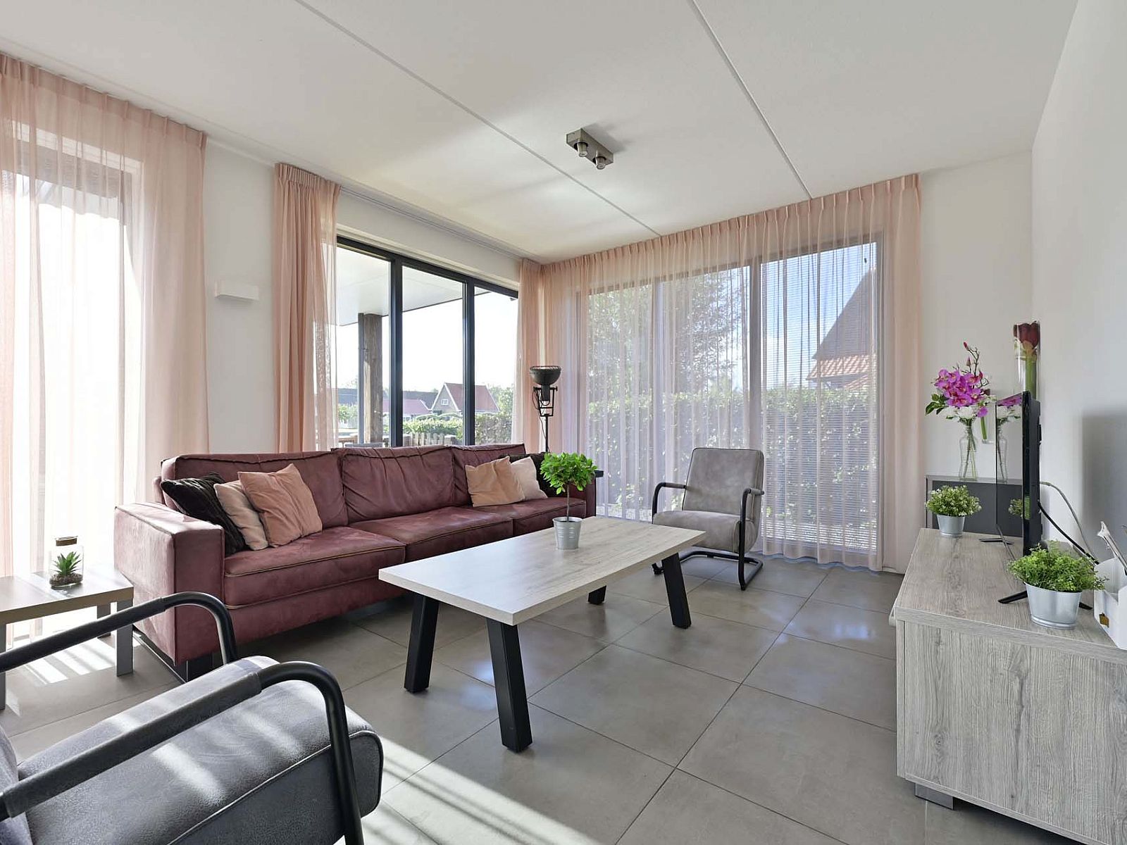 Lichte woonkamer van de vrijstaande woning in Ossenzijl, Noordwest Overijssel, met comfortabele zitplaatsen.