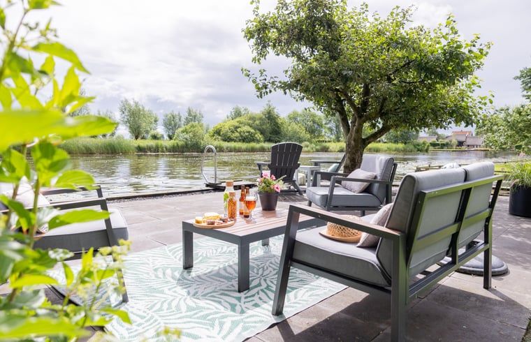 Terras aan het water bij Vakantiehuisje in Wetering, Overijssel. Ontspan met een prachtig uitzicht op de natuur.
