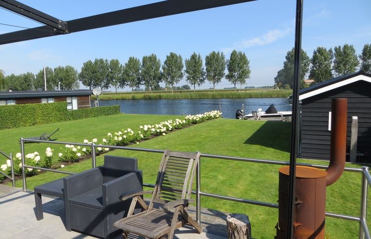 Terras bij Huisje in IJsselmuiden met uitzicht op de rivier, perfect voor rust in Overijssel.