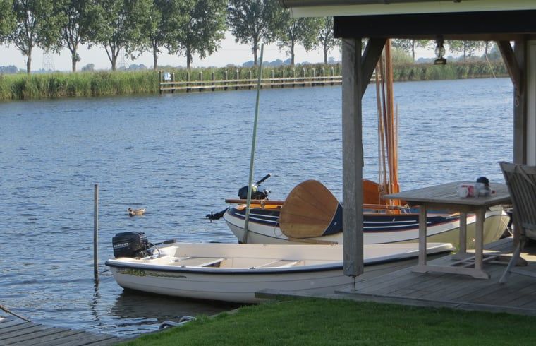 Bootjes aan de steiger van Huisje in IJsselmuiden, ideaal voor watersportliefhebbers in Noordwest Overijssel.