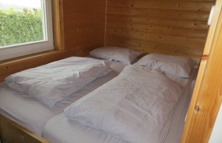 Comfortabele tweepersoonsslaapkamer in Huisje in IJsselmuiden, ideaal voor een rustige vakantie.