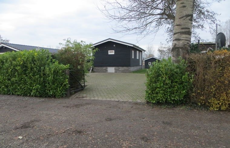 Toegangsweg naar Huisje in IJsselmuiden vakantiehuis, omgeven door groen in Overijssel.