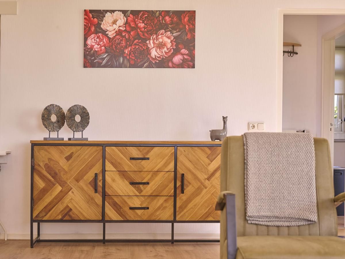 Stijlvolle inrichting in de woonkamer van Alpa Casa vakantiehuis, Rouveen, Overijssel met houten dressoir.