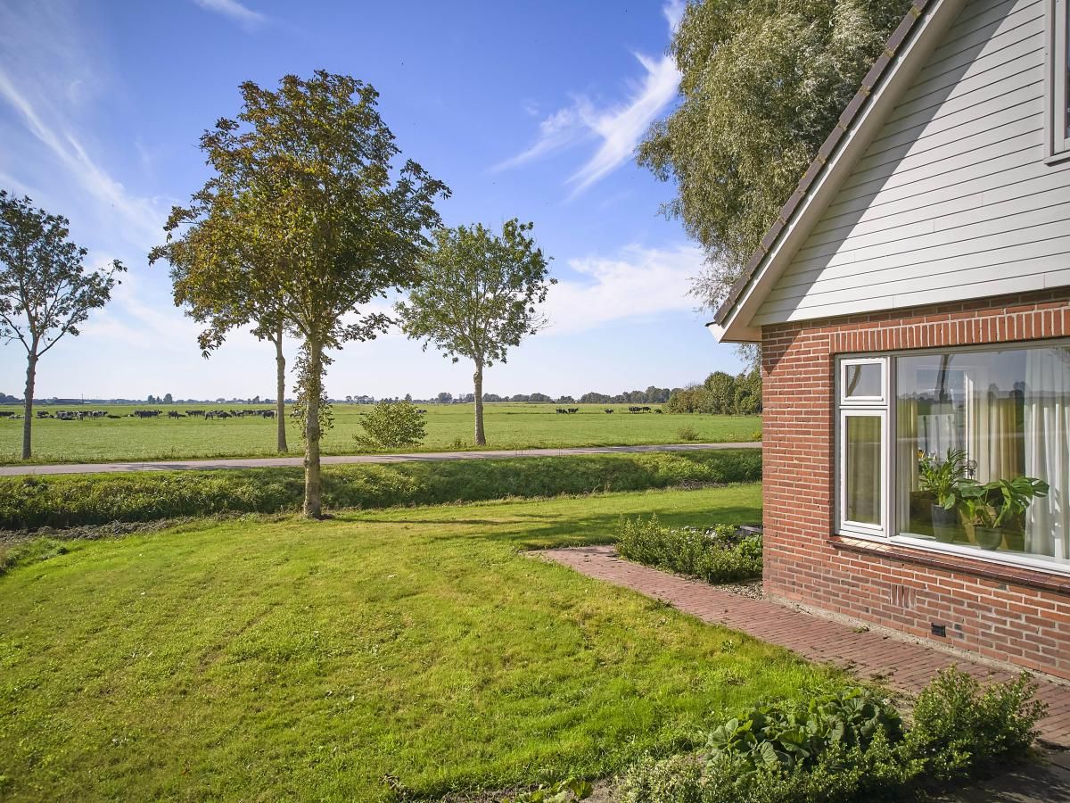 Groene tuin bij Alpa Casa vakantiehuis, Rouveen, Overijssel met uitzicht op het platteland.