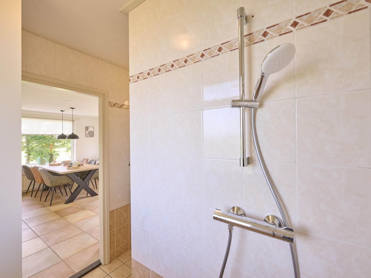Badkamer met douche in Alpa Casa vakantiehuis, Rouveen, Overijssel met moderne tegels.