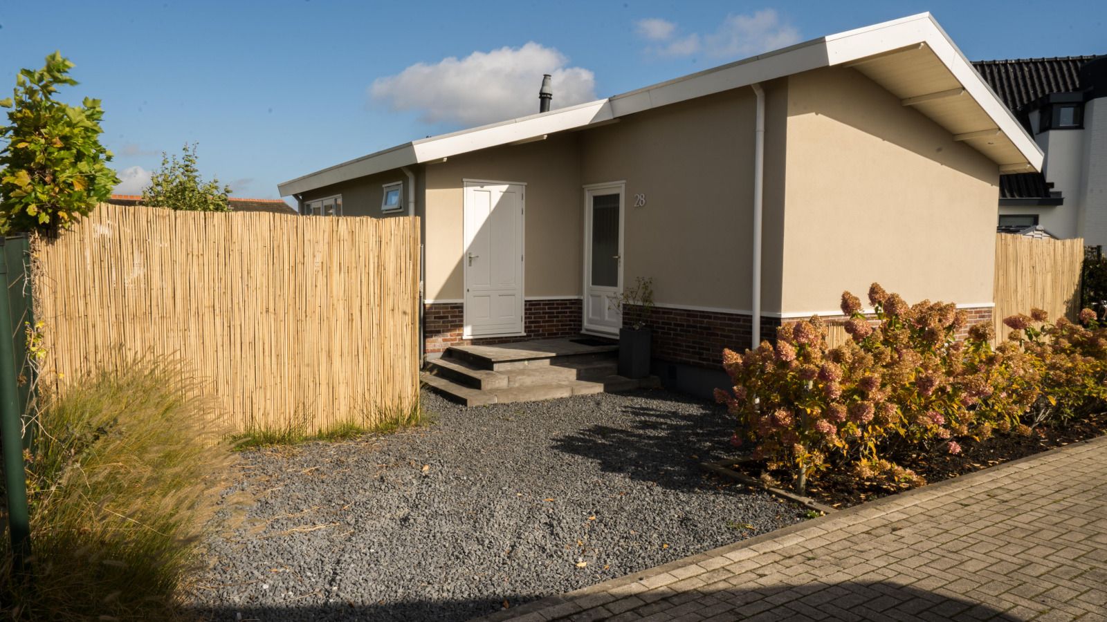 Geniessen Sie die sonnige Terrasse des Ferienhauses UT096 in Breukelen, Utrecht, mit bequemen Sitzgelegenheiten und Blick auf die gruene Umgebung.