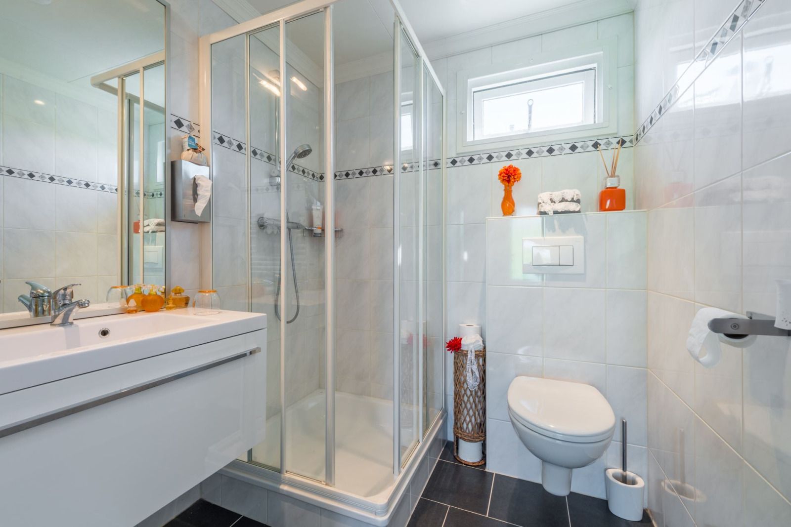 Ferienhaus UT096 in Breukelen, Utrecht, mit wunderschoenem Blick auf das Wasser und einer schoenen Terrasse, umgeben von bunten Blumen.