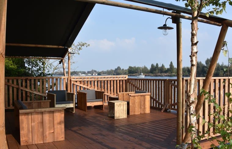 Geniessen Sie die Aussicht von der Terrasse des Huisje in Vinkeveen, einem Ferienhaus in Vinkeveen, Utrecht, umgeben von schoener Natur.
