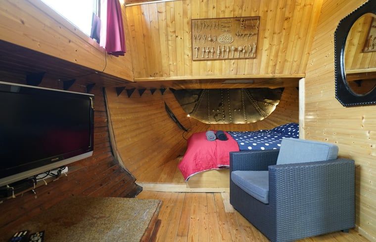 Cozy sitting area in Cottage in Vinkeveen, vacation home in Utrecht north, Utrecht with TV and bookshelf.