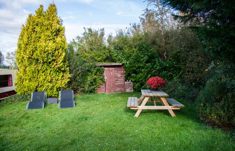 Outdoor area with picnic table at House in Vinkeveen, vacation home in Utrecht north, Utrecht surrounded by greenery.