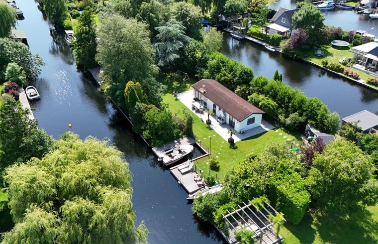 Luchtfoto van Huisje in Vinkeveen, vakantiehuis in Utrecht met groene omgeving en waterkanalen.