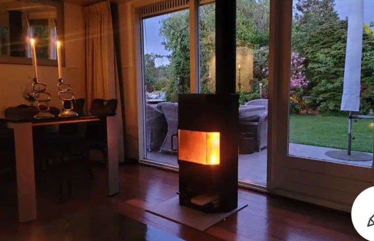 Sfeervolle woonkamer met open haard in Huisje in Vinkeveen, vakantieaccommodatie in Utrecht.