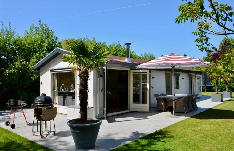 Zonnig terras bij Huisje in Vinkeveen, vakantiehuis in Utrecht met barbecue en parasol.