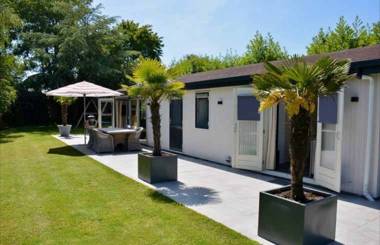 Grote tuin met speeltoestellen bij Huisje in Vinkeveen, vakantieaccommodatie in Utrecht noord.