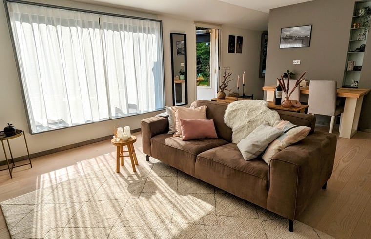 Lichte leefruimte in Vakantiehuis in Soest, Utrecht, met comfortabele bank en decoratieve elementen.
