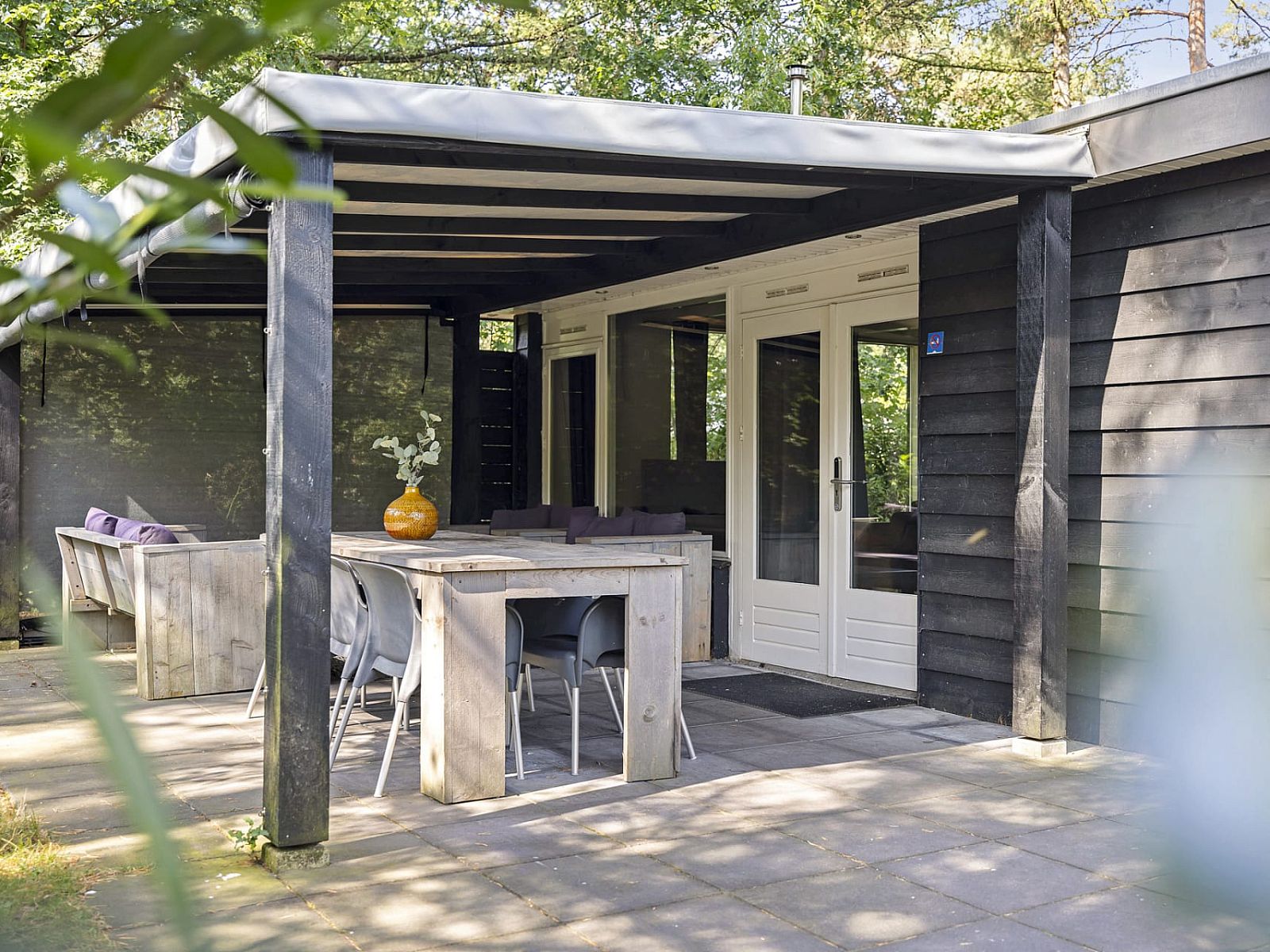 Veranda des Bungalows Schoonoord in Doorn, Utrechtse Heuvelrug, umgeben von Natur und Ruhe, ideal fuer einen erholsamen Urlaub.