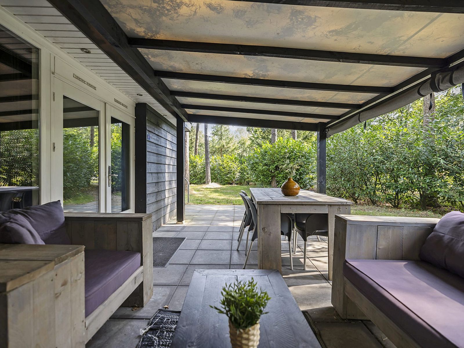 Geniessen Sie die geraeumige Veranda des Bungalows Schoonoord in Doorn, Utrechtse Heuvelrug. Perfektes Feriendomizil in gruener Umgebung.