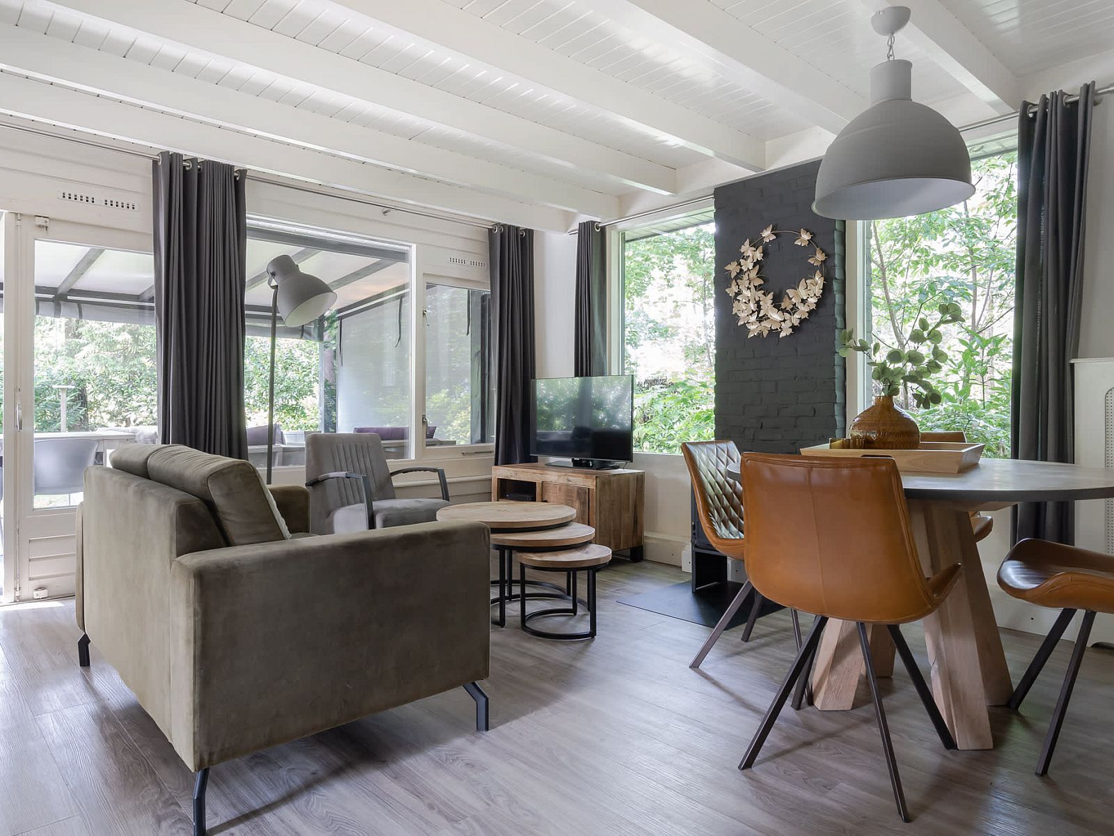 Gemuetliches Wohnzimmer im Bungalow Schoonoord, Doorn, Utrechtse Heuvelrug. Gemuetliche Einrichtung mit Blick auf die gruene Natur.