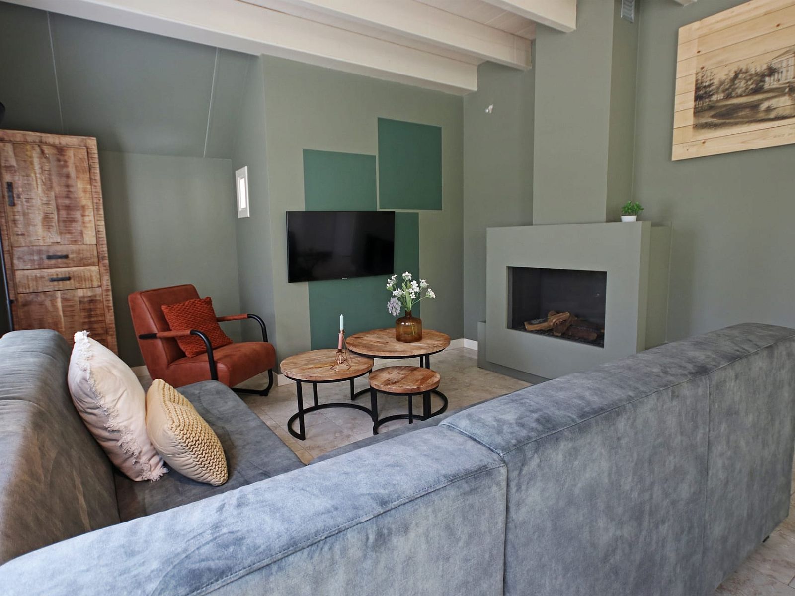 Gezellige woonkamer van Vakantiewoning Molenbosch in Doorn, Utrechtse Heuvelrug, met comfortabele zithoek en moderne open haard.