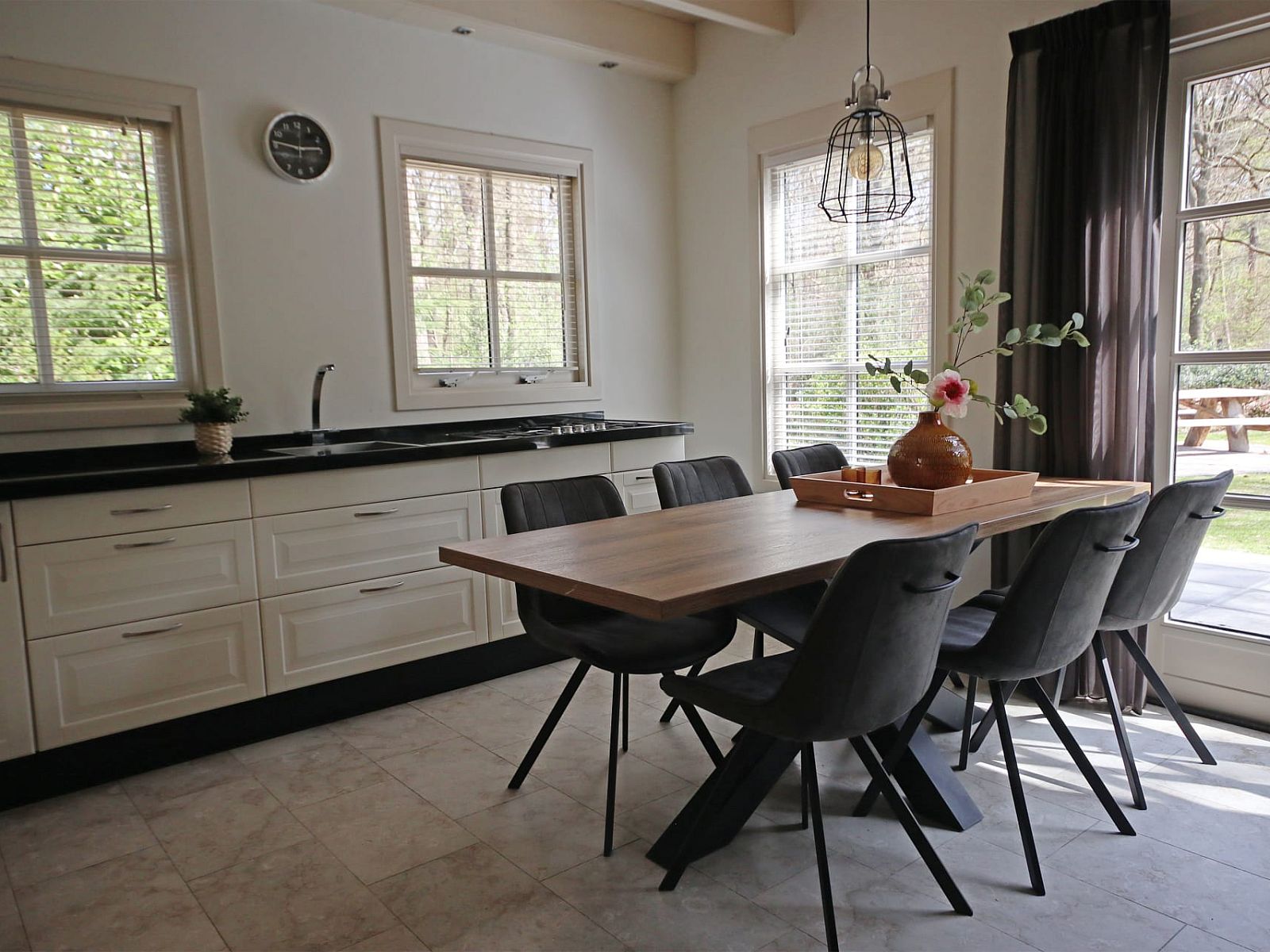 Gezellige eetruimte in Vakantiewoning Molenbosch, Doorn, Utrechtse Heuvelrug, met uitzicht op groene tuin en moderne inrichting.