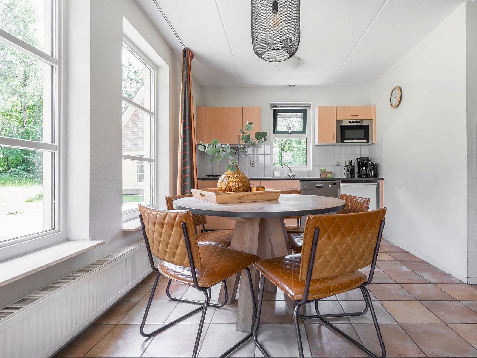 Gezellige eetkamer in Vakantiewoning Beukenrode, Doorn, Utrechtse Heuvelrug, met moderne keuken en veel natuurlijk licht.