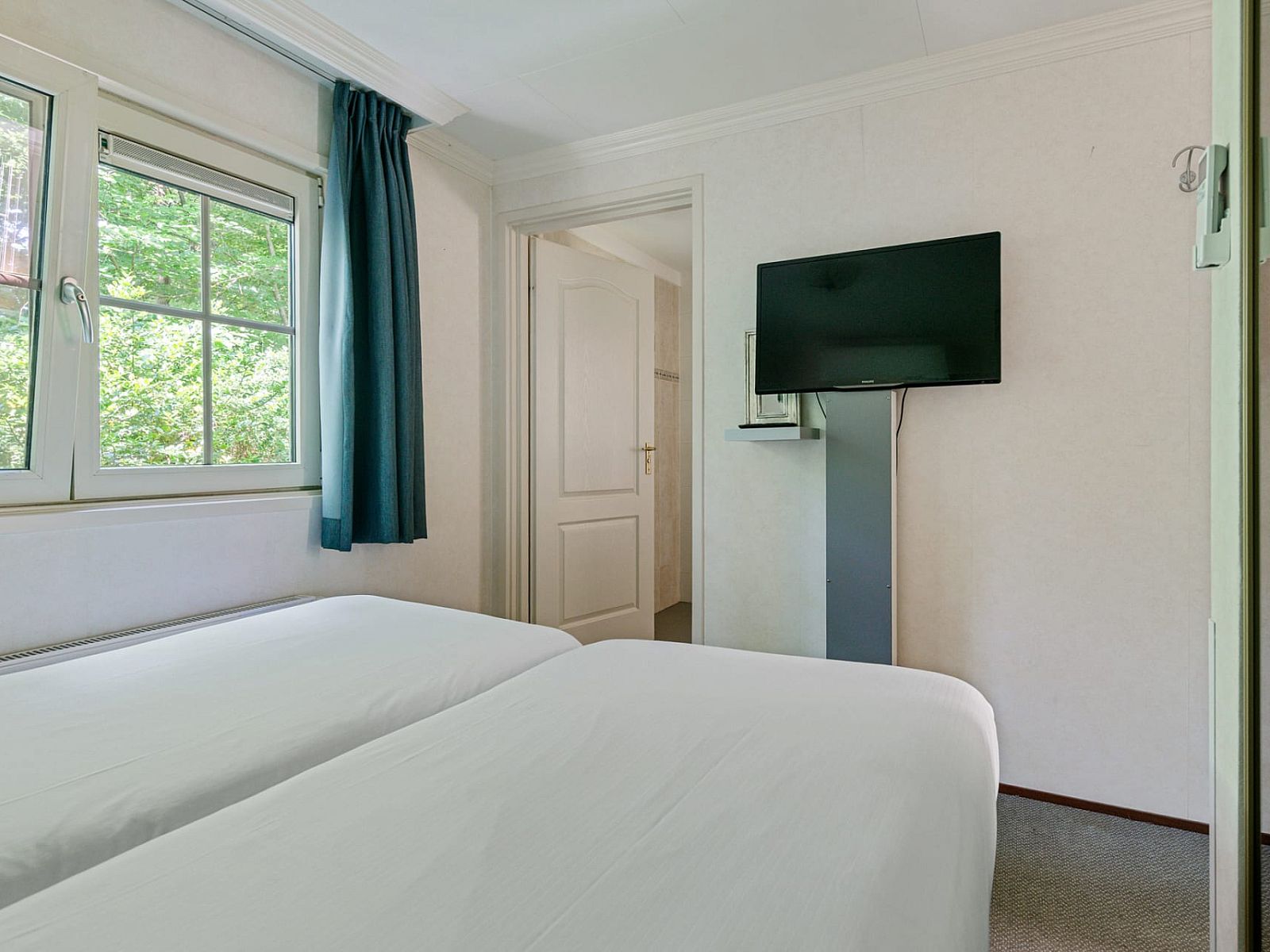 Sfeervolle slaapkamer in Vakantiewoning Drieburg, Doorn, Utrechtse Heuvelrug met comfortabel tweepersoonsbed en groene uitzicht.